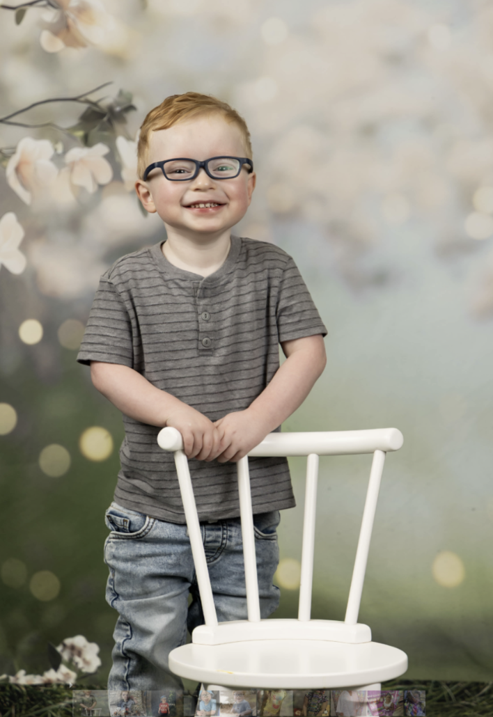 Carter standing by a white chair