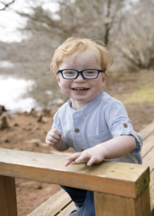 Carter smiling on a wooden bench